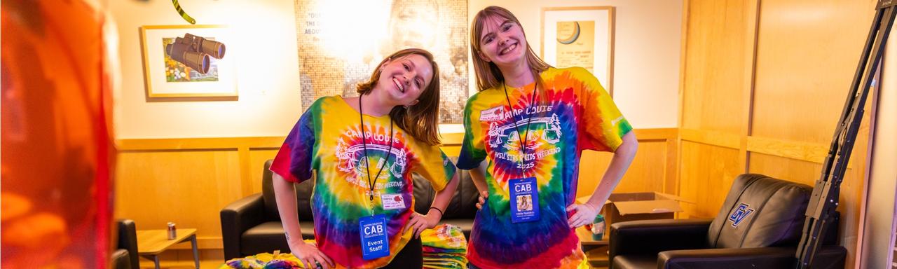 Two students wearing tye dye t-shirts that say "Camp Louie"